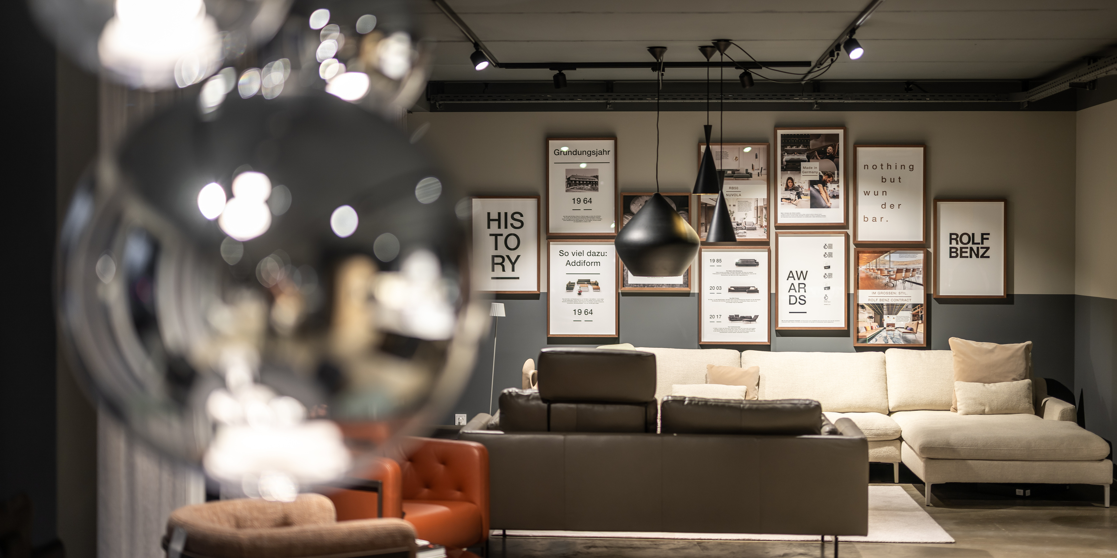 Aufnahme im Rolf Benz Haus Allgäu mit heller Sofalandschaft und Fotowand.